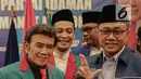 Ketua Umum Partai Amanat Nasional Zulkifli Hasan (kanan) bersama Ketum Partai Idaman Rhoma Irama (kiri) memegang jas partai PAN sebagai tanda deklarasi bergabungnya Partai Idaman ke PAN di Jakarta, Sabtu (12/5). (Liputan6.com/Faizal Fanani)