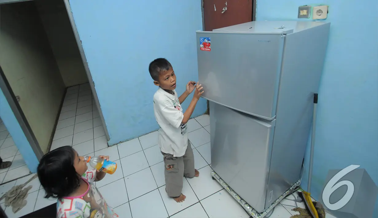 Sony Wakwaw dan adiknya melihat lemari es yang ada di rumah barunya di kawasan Cibubur, Jakarta Timur. Foto diambil pada Kamis (4/12/2014). (Liputan6.com/Herman Zakharia)