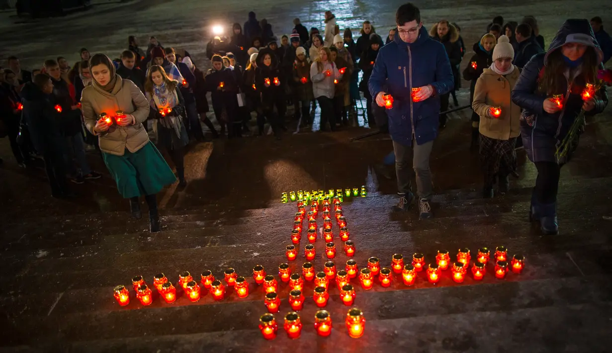 Sejumlah warga menempatkan lilin di depan Katedral Kristus Juruselamat Moskow, Rusia, Senin (12/2). Pesawat Saratov Airlines menghilang dari radar beberapa menit setelah berangkat dari Bandara Domodedovo ke Orsk. (AP Photo/Alexander Zemlianichenko)