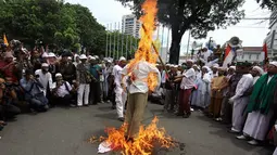 Dalam aksinya, massa melakukan pembakaran boneka di depan Balaikota, Jakarta, Senin (1/12/2014). (Liputan6.com/Faizal Fanani) 