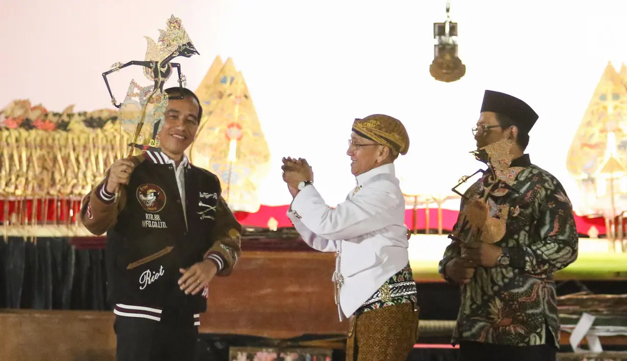 Presiden Joko Widodo (Jokowi) memainkan wayang kulit disaksikan dalang Ki Mantep Sudarsono (tengah) dalam Pagelaran Wayang Kulit 74 Tahun Indonesia Merdeka di halaman depan Istana Merdeka, Jakarta, Jumat (2/8/2019). Pagelaran wayang mengangkat tema "Kresno Jumeneng Ratu”.(Liputan6.com/Angga Yuniar)
