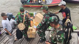 Satgas Kesehatan TNI menyalurkan bantuan berupa vaksin di Kabupaten Asmat, Papua, Jumat (19/1). Tim Kesehatan Daerah dari TNI diterjunkan ke distrik di wilayah Kabupaten Asmat menggunakan speedboat sebagai transportasi utama (LIputan6.com/Pool/Puspen TNI)