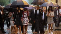 Sambil memegang payung di bawah guyuran hujan, rombongan tersebut berjalan disambut oleh Menteri Luar Negeri Kuba Bruno Rodriguez.