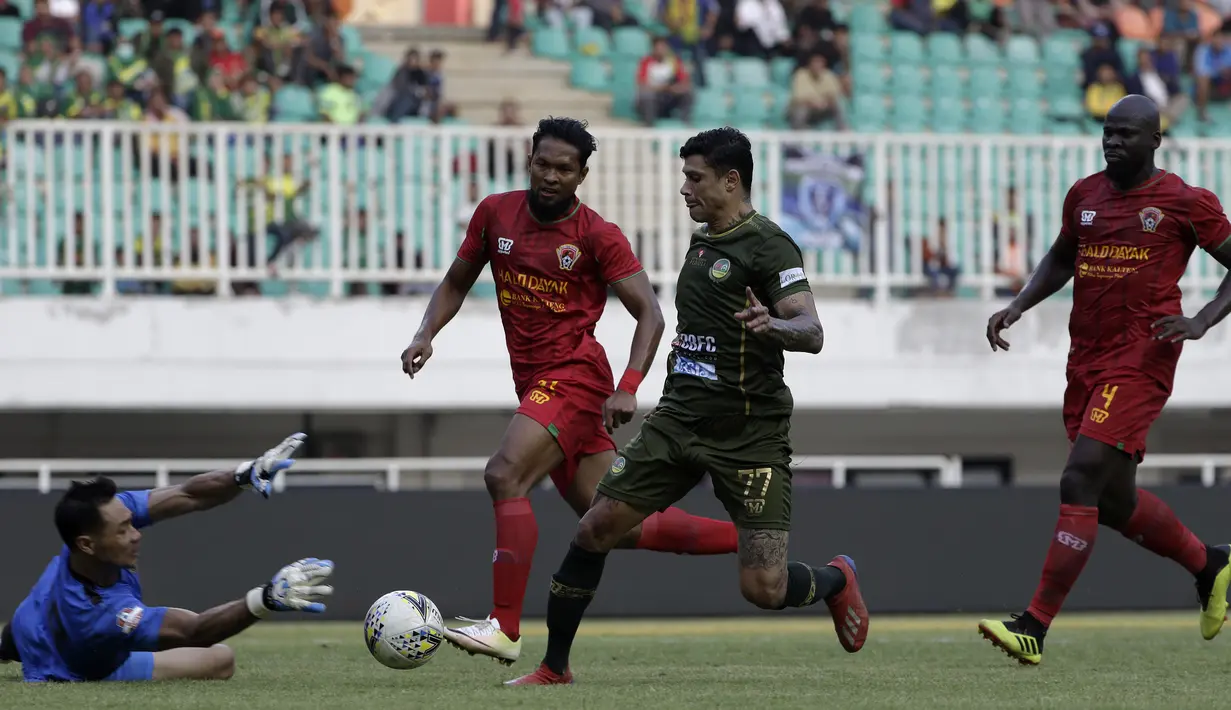 Gelandang Tira Persikabo, Ciro Henrique, berusaha melewati kiper Kalteng Putra, Dimas Galih, pada laga Shopee Liga 1 di Stadion Pakansari, Bogor, Jumat (26/7). Tira Persikabo menang 5-2 atas Kalteng. (Bola.com/Yoppy Renato)