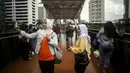 Warga berswafoto dengan kamera ponsel di Jembatan Penyeberangan Orang (JPO) Pinisi, Jalan Jenderal Sudirman, Karet, Jakarta, Selasa (15/3/2022). Belum lama ini, Pemprov DKI Jakarta meresmikan JPO berbentuk spesial tersebut yang membentang di atas Jalan Jenderal Sudirman. (Liputan6.com/Johan Tallo)