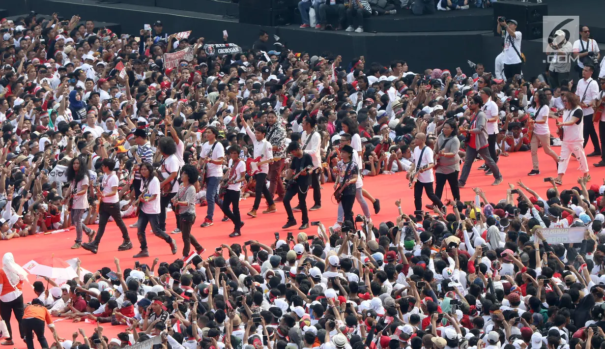 Sejumlah musisi dan artis ibukota membawakan lagu pada kampanye akbar capres dan cawapres Joko Widodo (Jokowi)-Ma'ruf Amin di Stadion Utama GBK, Senayan, Jakarta, Sabtu (13/15). Penampilan kolaborasi dari 100 gitaris Indonesia meramaikan pagelaran Konser Putih Bersatu. (Liputan6.com/Angga Yuniar)