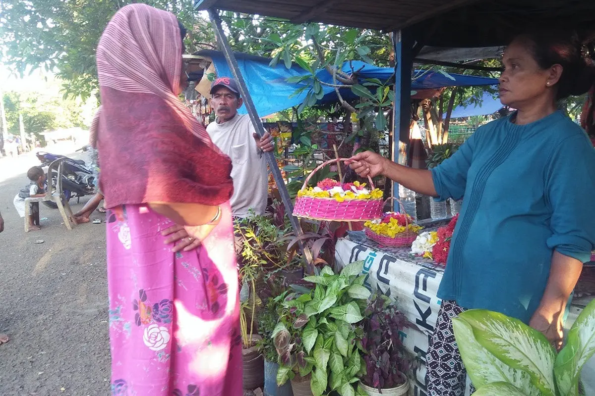 Nuraeni, pedagang bunga tertua di TPU Panaikang sedang tawarkan bunga ke peziarah (Liputan6.com/ Eka Hakim)