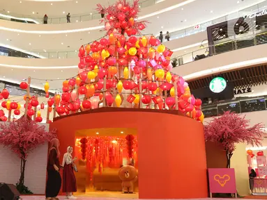 Pengunjung melihat instalasi spring lights di Atrium Senayan City, Jakarta, Rabu (22/1/2020). Jelang Tahun Baru Imlek, Senayan City menghadirkan instalasi Mega Brown setinggi 2,5 meter dan Pop Up Shop terbesar yang bisa dinikmati mulai 17 Januari sampai 9 Februari 2020.(Liputan6.com/Herman Zakharia)