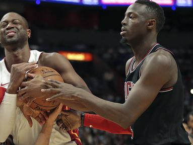 Pemain Miami Heat, Dwyane Wade (tengah) berebut bola dengan dua pemain Chicago Bulls pada laga NBA basketball game, di American Airlines Arena, Miami, (29/3/2018). Heat menang 103-92. (AP/Joel Auerbach)