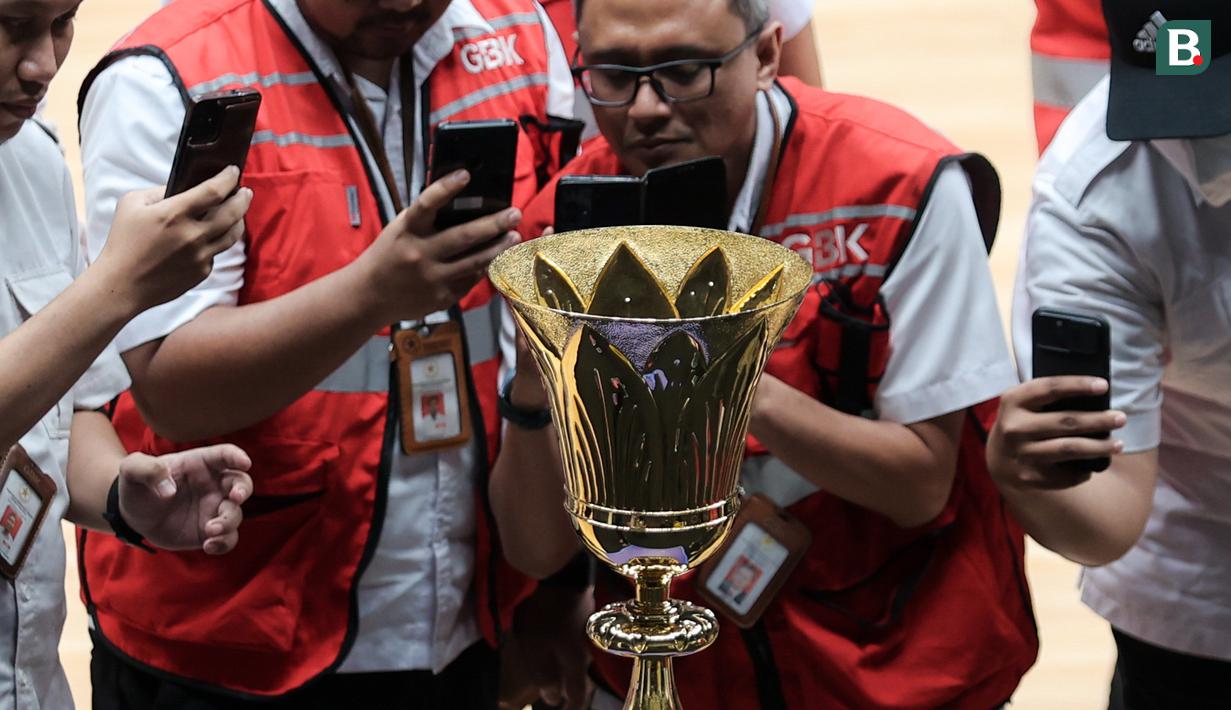 Sejumlah undangan mengabadikan foto trofi Piala Dunia Basket atau sering disebut Naismith Trophy menggunakan gawainya setelah peresmian Indonesia Arena pada Senin (07/08/2023) di Senayan, Jakarta. (Bola.com/Bagaskara Lazuardi)