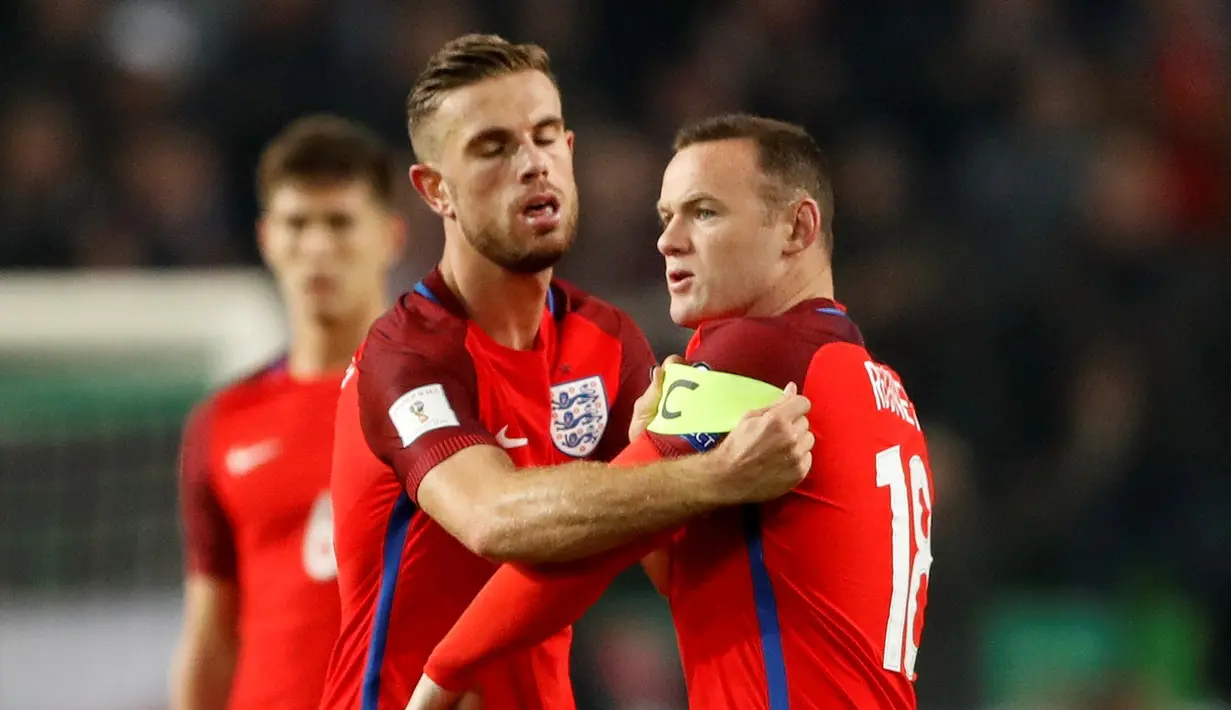 Jordan Henderson, memasang ban kapten di lengan Wayne Rooney saat melawan Slovenia pada laga Grup F Kualifikasi Piala Dunia 2018 zona Eropa, di Stadion Stozice, Ljubljana, Rabu (12/10/2016) dini hari WIB. (Action Images via Reuters/Carl Recine)