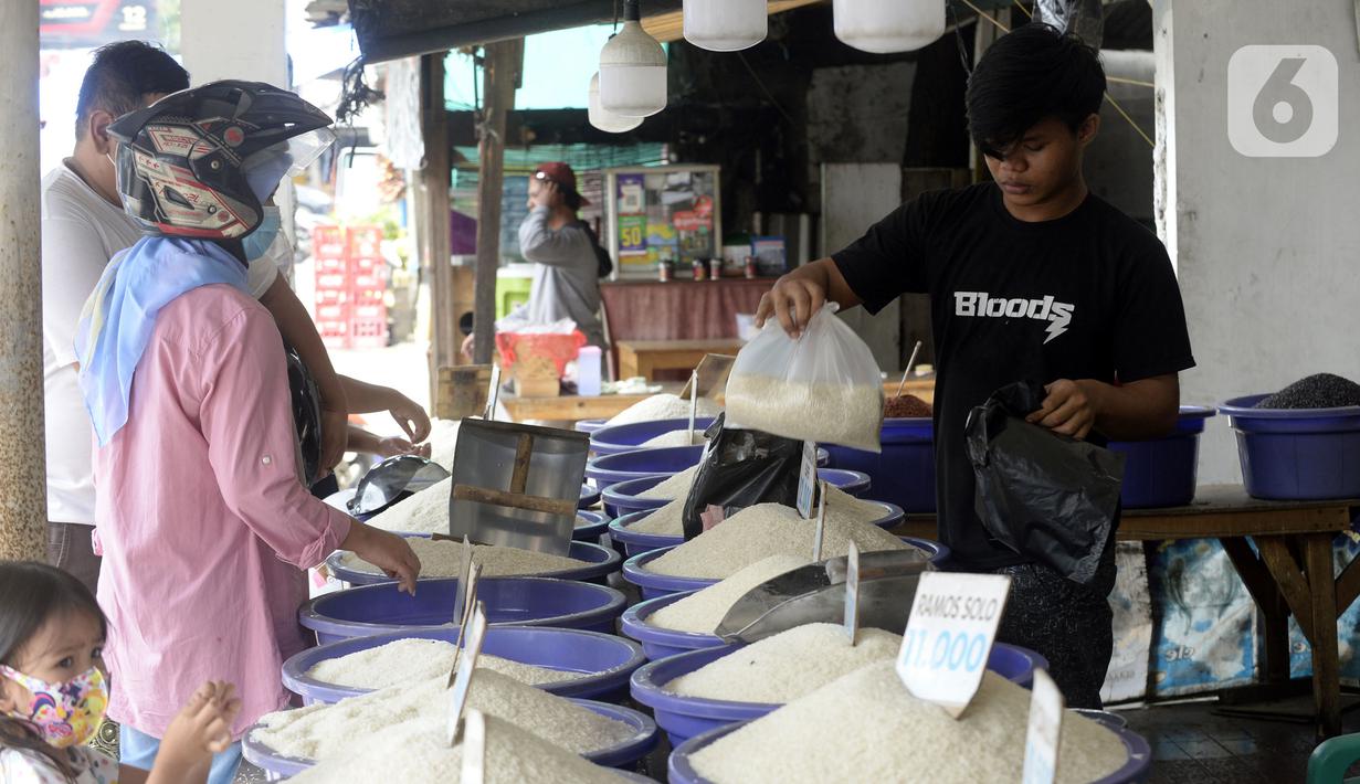 Pedagang beras melayani pembeli di pinggir Jalan Raya Pamulang, Tangerang Selatan, Banten, Jumat (11/12/2020). Jelang Natal dan Tahun Baru 2021, harga beras dipasaran masih normal tidak ada kenaikan. (merdeka.com/Dwi Narwoko)