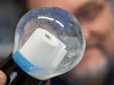 Pemilik perusahaan Original Vienna Snow Globes, Erwin Perzy III memegang bola salju yang berisi gulungan kertas toilet di Wina, Austria, pada 17 April 2020. Bola salju yang memiliki desain istimewa ini terinspirasi dari panic buying pada awal virus corona Covid-19. (ALEX HALADA/AFP)