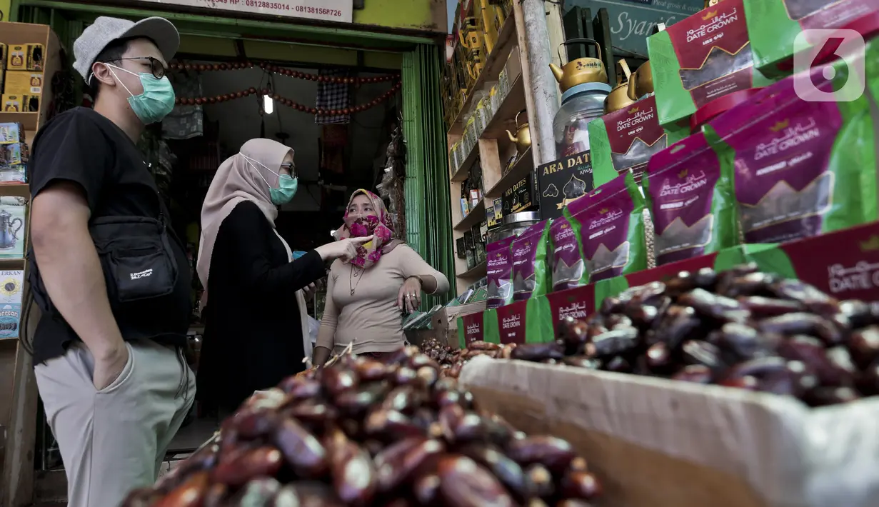 Pedagang kurma melayani pembeli di Pasar Tanah Abang, Jakarta, Rabu (22/4/2020). Pandemi COVID-19 membuat lesu penjualan kurma, keuntungan pedagang menurun hingga 80 persen lebih padahal pada tahun sebelumnya menjelang Ramadan biasanya ramai pembeli. (Liputan6.com/Johan Tallo)