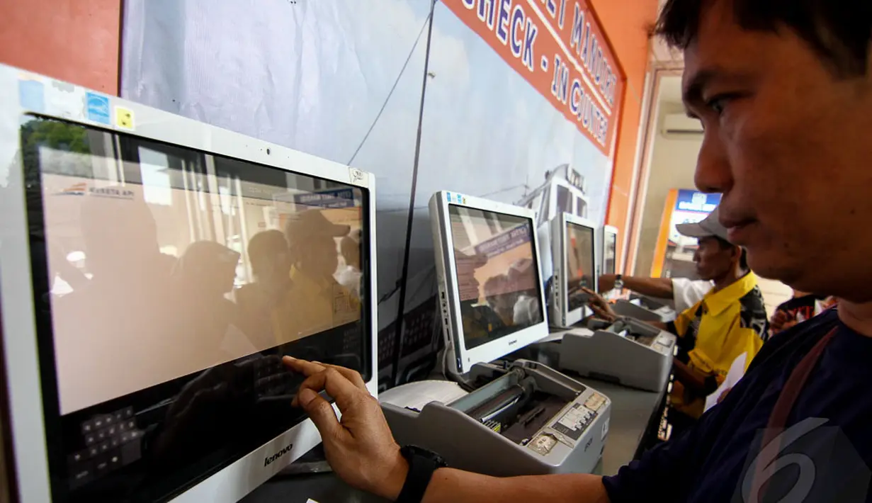 Seorang calon penumpang mencoba mencetak tiket secara mandiri di Stasiun Senen, Jakarta, Senin (28/4/2014) (Liputan6.com/Faizal Fanani).