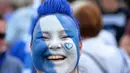 Seorang suporter menghias wajahnya dengan warna kebanggan Leicester City saat merayakan titel juara Liga Inggris di Stadion King Power, (7/5/2016). (AFP/Glyn Kirk)
