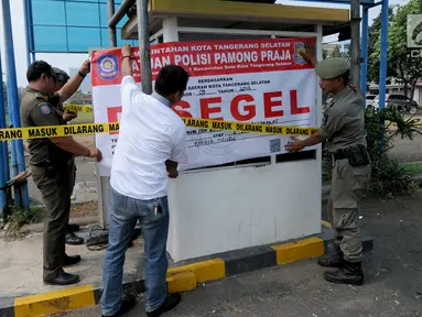 Satuan Polisi Pamong Praja (Satpol PP) Kota Tangerang Selatan menyegel areal parkir liar di kawasan BSD, Rabu (3/10). Penyegelan loket parkir tersebut dilakukan lantaran pihak pengelola parkir tidak memiliki izin. (Merdeka.com/Arie Basuki)