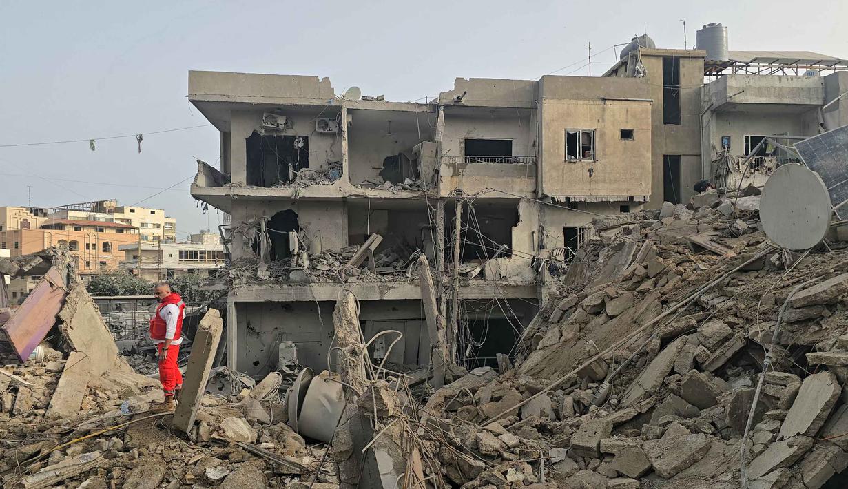 Kementerian Kesehatan Lebanon mengatakan korban tewas karena serangan Israel setidaknya mencapai lebih dari 1.000 orang. Tampak dalam foto, seorang petugas penyelamat memeriksa puing-puing bangunan yang hancur di lokasi serangan Israel di wilayah Maarakeh, Lebanon selatan, dekat kota pesisir Tyre pada Sabtu 4 April 2026. (Kawnat HAJU/AFP)