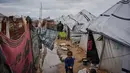 Hujan deras menyebabkan banjir di sejumlah kamp-kamp pengungsian, termasuk wilayah Nuseirat, Al-Mawasi dan Khan Younis. Tampak dalam foto, Nanaa Abu Jari memasak di luar tendanya setelah tenda tersebut terendam air hujan di Nuseirat, Jalur Gaza tengah, Jumat, 2 Januari 2026. (AP Photo/Abdel Kareem Hana)