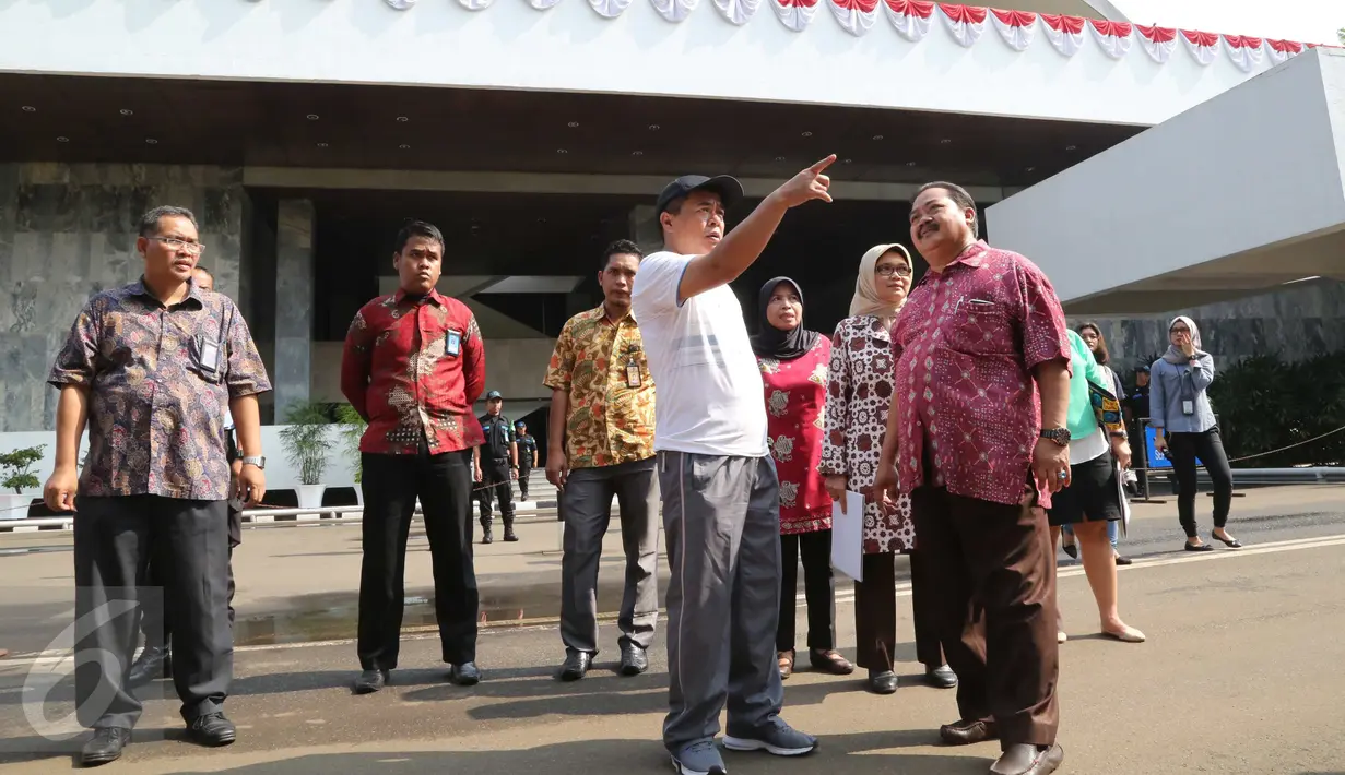 Ketua DPR RI Ade Komarudin (topi) berbincang ketika meninjau persiapan Pidato Kenegaraan di Gedung Nusantara, komplek Parlemen, Jakarta, Jumat (12/8). Saat melakukan peninjauan, Akom didampingi Sekjen DPR dan jajarannya. (Liputan6.com/Angga Yuniar)