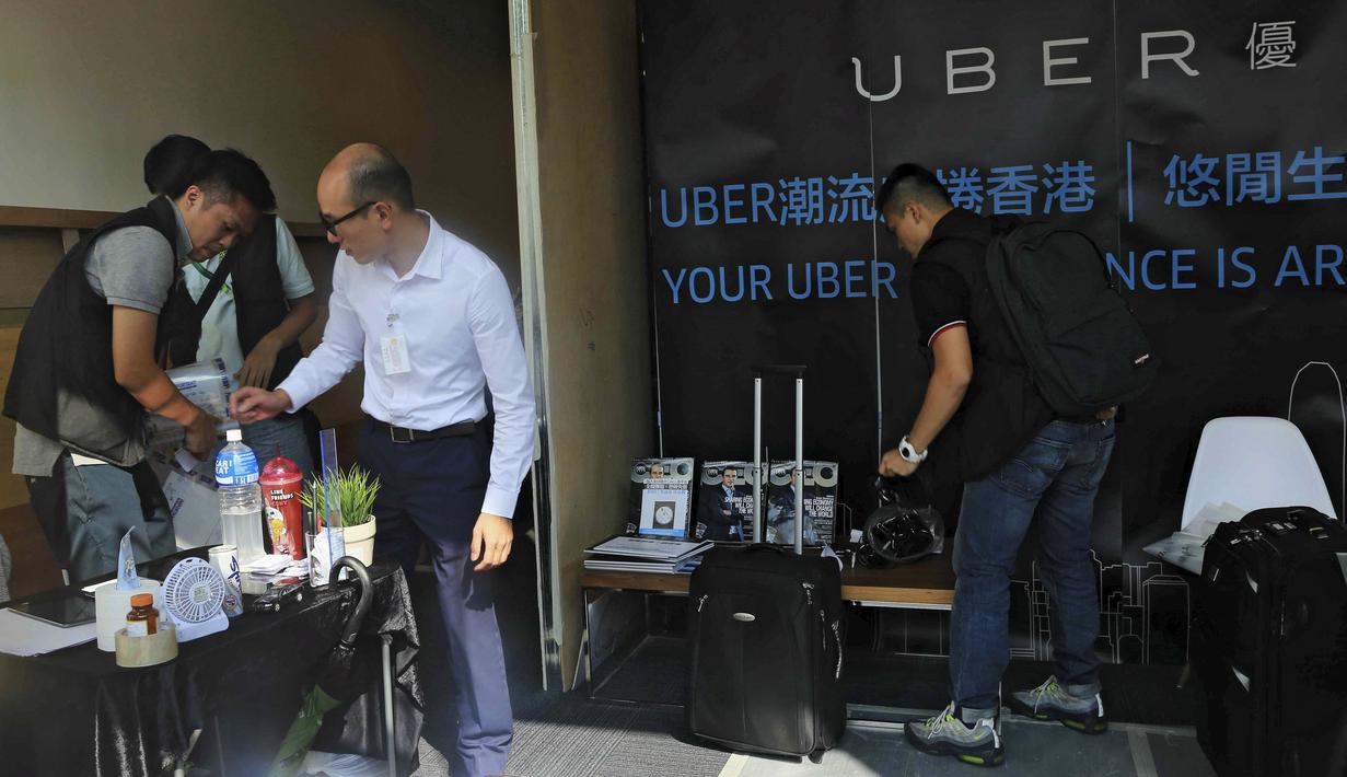 Polisi Hong Kong melakukan razia di kantor jasa pelayanan taxi Uber Inc, Selasa (11/8/2015). Polisi berhasil mengamankan 5 orang yang tertangkap basah memberikan jasa pelayanan sebagai sopir taxi dengan kendaraan ilegal. (REUTERS/Apple Daily)