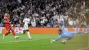 Vinicius sukses mengonversi umpan Federico Valverde dalam skema serangan balik. Ia dengan tenang menembak bola ke pojok kanan dan membuat skor menjadi 2-1. (AFP/Pierre-Philippe Marcou)