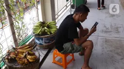 Seorang pria menggunakan smartphone di Jakarta, Senin (11/1/2021). Menurut Perusahan Pasar riset IDC ada pertumbuhan penggunaan smartphone sebesar 49 persen dibanding kuartal sebelumnya, dan 21 persen dari periode yang sama tahun lalu. (Liputan6.com/Angga Yuniar)