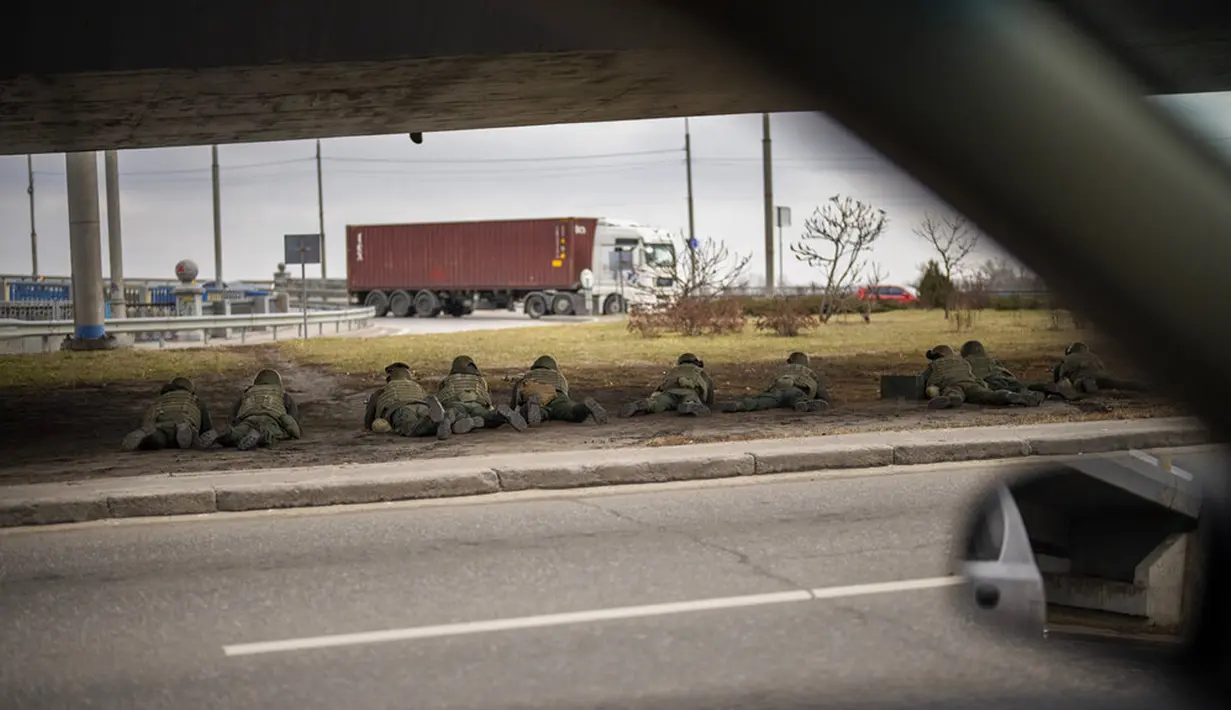 Tentara Ukraina mengambil posisi di bawah jembatan saat melakukan tembakan di dalam Kota Kiev, Ukraina, Jumat (25/2/2022). Rusia menekan invasinya sampai ke pinggiran Kiev usai melepaskan serangan udara di kota-kota dan pangkalan militer serta mengirimkan pasukan dan tank.(AP Photo/Emilio Morenatti)