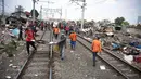 Petugas memindahkan puing bangunan liar usai pembongkaran di pinggiran rel kawasan Tanah Abang, Jakarta, Kamis (7/8/14). (Liputan6.com/Faizal Fanani)
