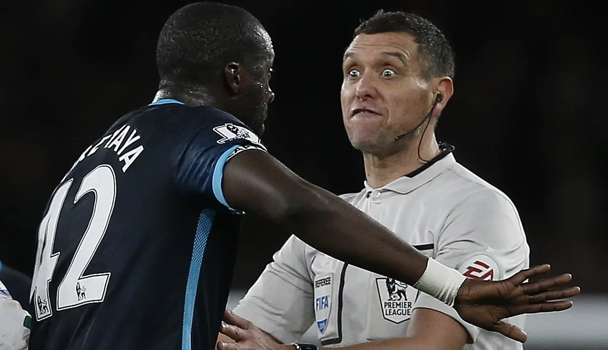 Wasit Andre Marriner (kanan) terlihat beradu mulut dengan pemain Manchester City, Yaya Toure pada lanjutan Liga Premier Inggris di Stadion  Emirates, London, Selasa (22/12/2015) dini hari WIB. (AFP Photo/Adrian Dennis)