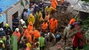 Pasukan Tanggap Bencana Nasional dan tim penyelamat lainnya memeriksa lokasi tanah longsor di daerah kumuh di Mumbai, India, Minggu (18/7/2021). Sebanyak 18 orang tewas setelah beberapa rumah hancur oleh dinding yang runtuh dan akibat tanah longsor yang dipicu oleh hujan lebat. (Sujit Jaiswal/AFP)
