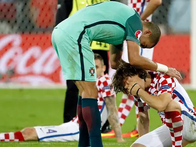 Bek Portugal, Pepe (kiri) saat menenangkan gelandang Kroasia Luka Modric usai pertandingan babak 16 besar piala Eropa 2016 di  Stade Bollaert, Lens , Prancis, (26/6). Portugal tumbangkan Kroasia dengan skor tipis 1-0. (REUTERS / Gonzalo Fuentes)