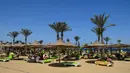Wisatawan bersantai sembari menikmati mahatari di pantai kota wisata Laut Merah Mesir, Hurghada pada 3 April 2019. Laut Merah merupakan salah satu destinasi wisata unggulan Mesir, selain Piramida di Kairo, kuil-kuil di Luxor, atau Sungai Nil.  (Mohamed el-Shahed / AFP)