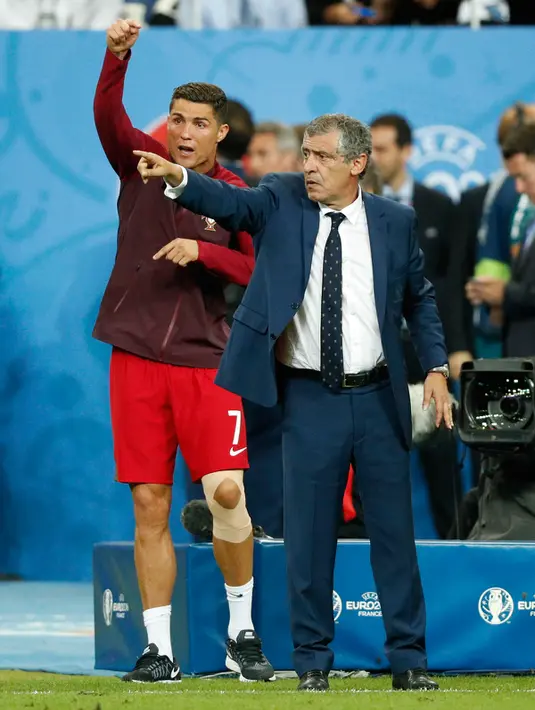 Ronaldo berdiri di samping pelatihnya Fernando Santos saat menjadi asisten pelatih dadakan saat laga final Euro 2016 antara Portugal vs Prancis di Stade de France, Saint-Denis, Paris, Prancis, Senin (11/6). (REUTERS/John Sibley)