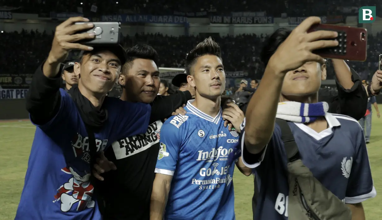 Suporter melakukan foto bersama dengan pemain Persib Bandung, Kim Jeffrey Kurniawan, usai mengalahkan Persija Jakarta pada laga Liga 1 di Stadion GBLA, Jawa Barat, Minggu (23/9/2018). Persib menang 3-2 atas Persija. (Bola.com/M Iqbal Ichsan)