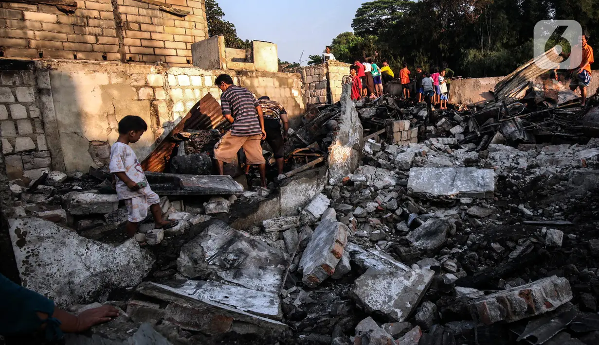 Warga memilah barang yang masih bisa diselamatkan di reruntuhan rumah akibat kebakaran yang melanda pemukiman di jalan Bojong Kavling RT 16/RW04 Kelurahan Rawa Buaya, Jakarta, Rabu (5/1/2022). Kebakaran terjadi Selasa (4/1/2022) menghanguskan setidaknya 14 rumah warga. (Liputan6.com/Johan Tallo)