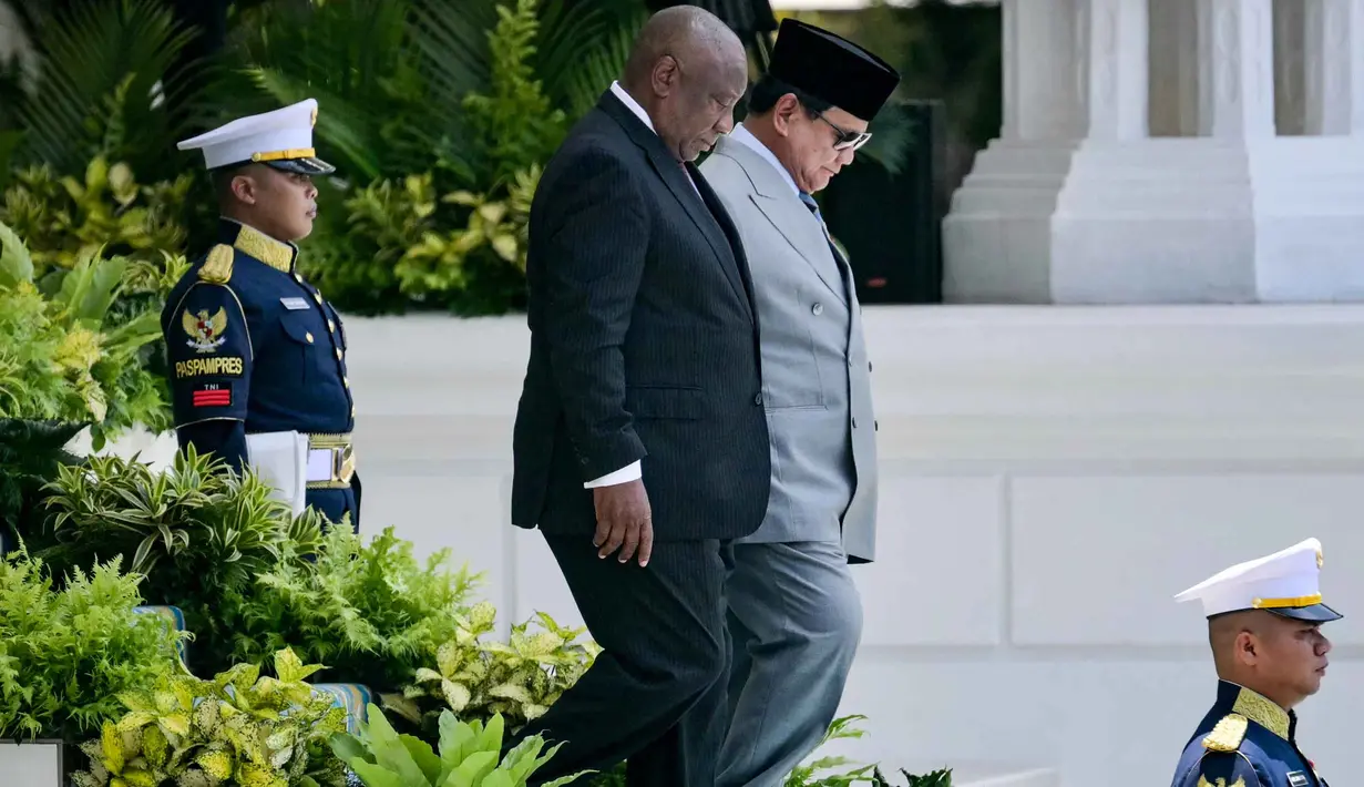 Presiden Republik Indonesia Prabowo Subianto (kanan) berjalan bersama Presiden Afrika Selatan Cyril Ramaphosa untuk memeriksa pasukan kehormatan di Istana Kepresidenan, Jakarta pada Rabu 22 Oktober 2025. (Bay ISMOYO/AFP)