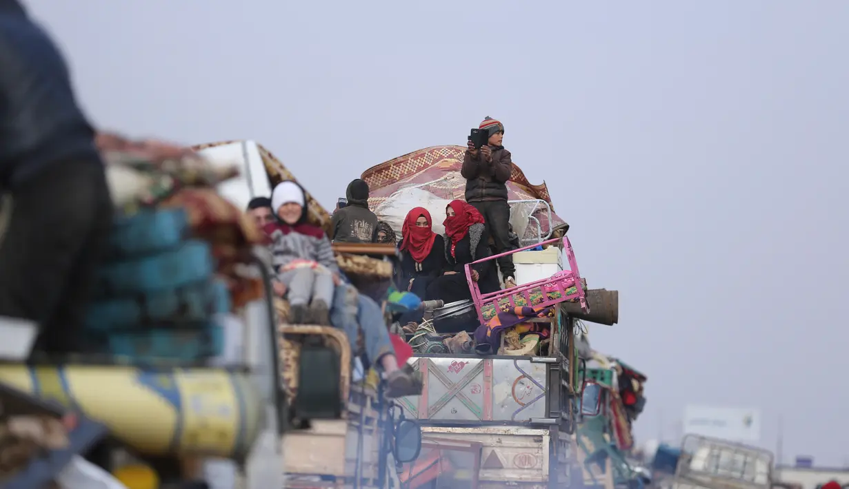 Warga melarikan diri menuju perbatasan Turki di Provinsi Idlib, Suriah, Rabu (29/1/2020). Kemajuan serangan pasukan pemerintah Suriah yang didukung Rusia atas Idlib memaksa ratusan ribu warga mengungsi ke tempat lebih aman. (AP Photo/Ghaith Alsayed)