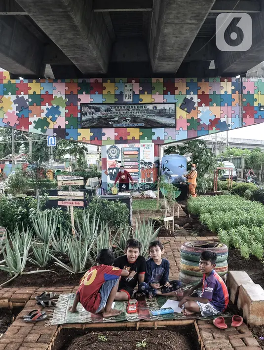 Anak-anak saat bermain di taman kolong flyover Cipinang, Jakarta, Senin (1/2/2021). Selain sayur seperti sawi dan kangkung, taman ini juga dilengkapi kolam ikan yang hasil panennya untuk dikonsumsi oleh warga sebagai program ketahanan pangan. (merdeka.com/Iqbal S. Nugroho)