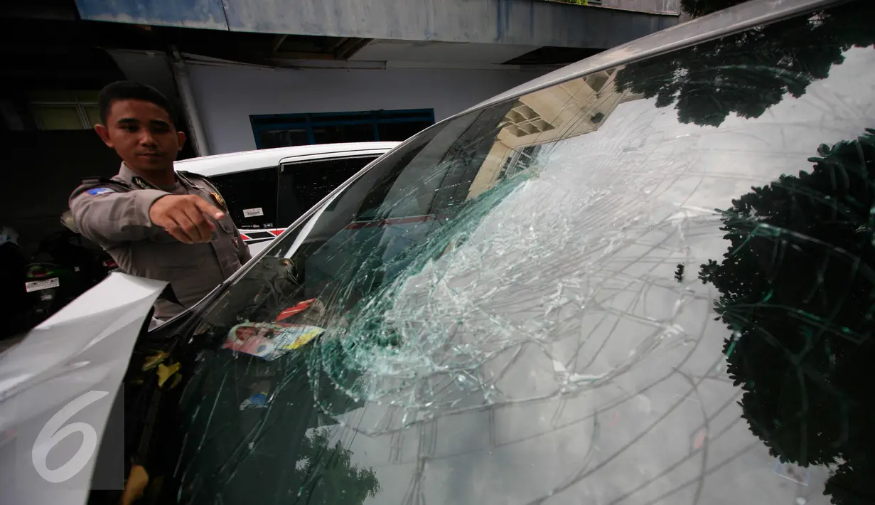 Petugas menunjukan mobil yang ringsek akibat kecelakaan lalulintas di simpang empat Tugu Pal Putih Yogyakarta, Senin (30/5). Kecelakaan yang terjadi pada minggu (29/5) pagi ini menewaskan 2 orang. (Boy Harjanto)