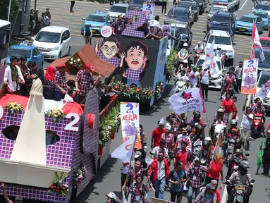 Pasangan Basuki T Purnama dan Djarot Saiful Hidayat menyapa warga saat berada di mobil karnaval di Thamrin, Jakarta, Sabtu (29/10). Karnaval tersebut merupakan bentuk kampanye damai untuk pemilihan Gubernur DKI Jakarta. (Liputan6.com/Angga Yuniar)