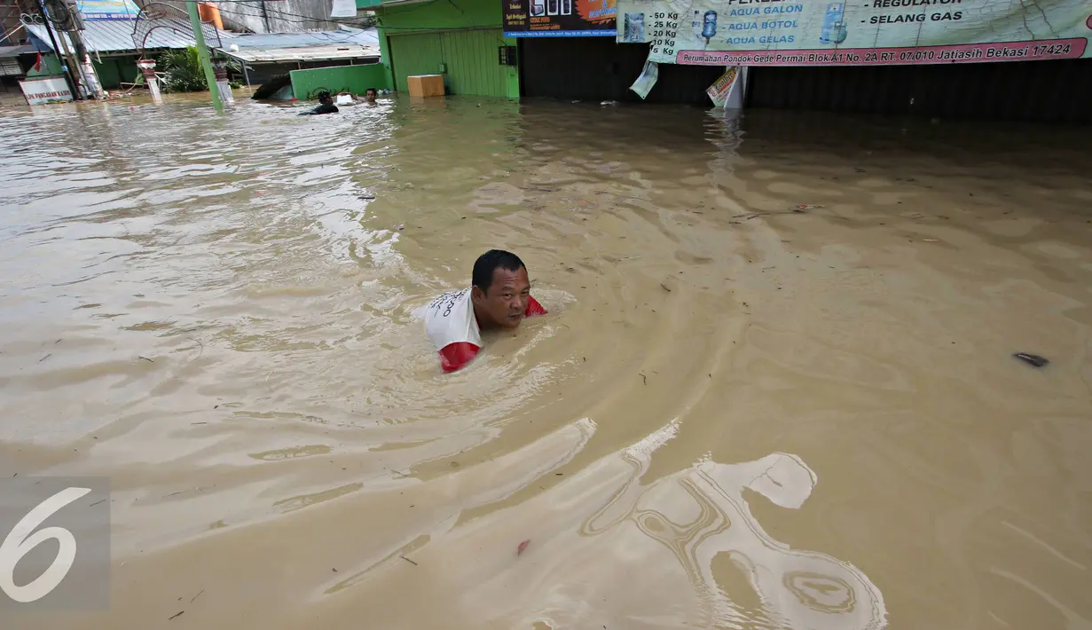 Warga menerobos banjir yang menggenangi Perumahan Pondok Gede Permai, Bekasi, Jawa Barat, Kamis (21/4). Banjir dengan ketinggian tiga meter yang berasal dari meluapnya Sungai Cikeas. (Liputan6.com/ Immanuel Antonius)