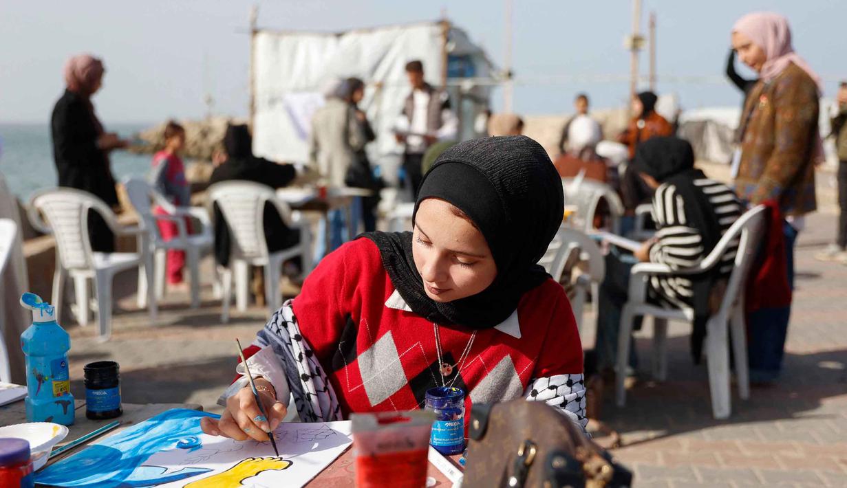 Para perempuan muda melukis di pelabuhan Kota Gaza pada Kamis 12 Februari 2026. Sejumlah aktivis perempuan menggelar Breath and Paint workshop atau lokakarya Bernapas dan Melukis. (Omar AL-QATTAA/AFP)