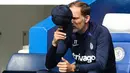 Pelatih Chelsea, Thomas Tuchel menutup wajahnya dari semburan sinar matahari dengan topinya saat memantau jalannya pertandingan pekan keenam Liga Inggris 2022/2023 antara Chelsea melawan West Ham United. (AFP/Adrian Dennis)