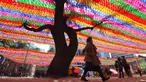Pengunjung melihat lampion yang terpasang di Jogye Temple jelang perayaan ulang tahun Buddha, Seoul, Rabu (12/4). ‘Lotus Lantern Festival’ menjadi salah satu perayaan yang ditunggu-tunggu oleh warga Korea Selatan. (AFP PHOTO / JUNG Yeon-Je) 