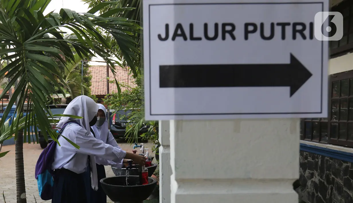 Para siswi mencuci tangan sebelum mengikuti Pembelajaran Tatap Muka Terbatas (PTMT) di SMPN 1 Depok, Depok, Jawa Barat, Senin (4/10/2021). PTMT diberlakukan dengan protokol kesehatan dan pembelajaran hanya dilakukan seminggu dua kali selama dua jam. (Liputan6.com/Herman Zakharia)