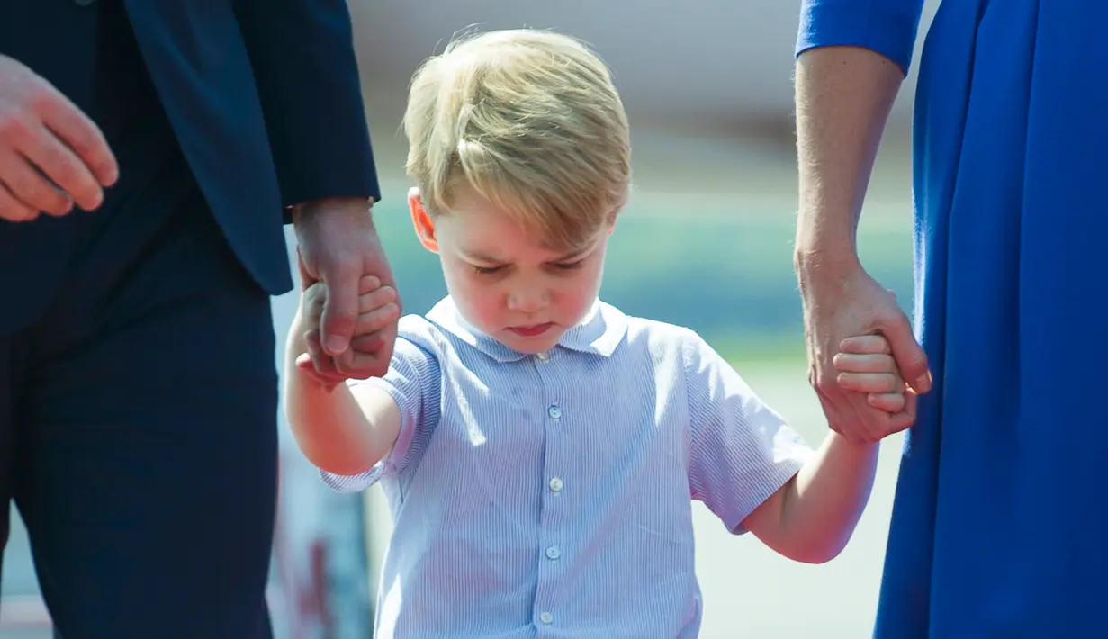Ekspresi Pangeran George setibanya di bandara Tegel bersama orang tuanya, Pangeran William dan Kate Middleton serta sang adik Putri Charlotte di Berlin, Rabu (19/7). George kelihatan lelah dan mengantuk saat turun pesawat. (Steffi Loos/Pool Photo via AP)