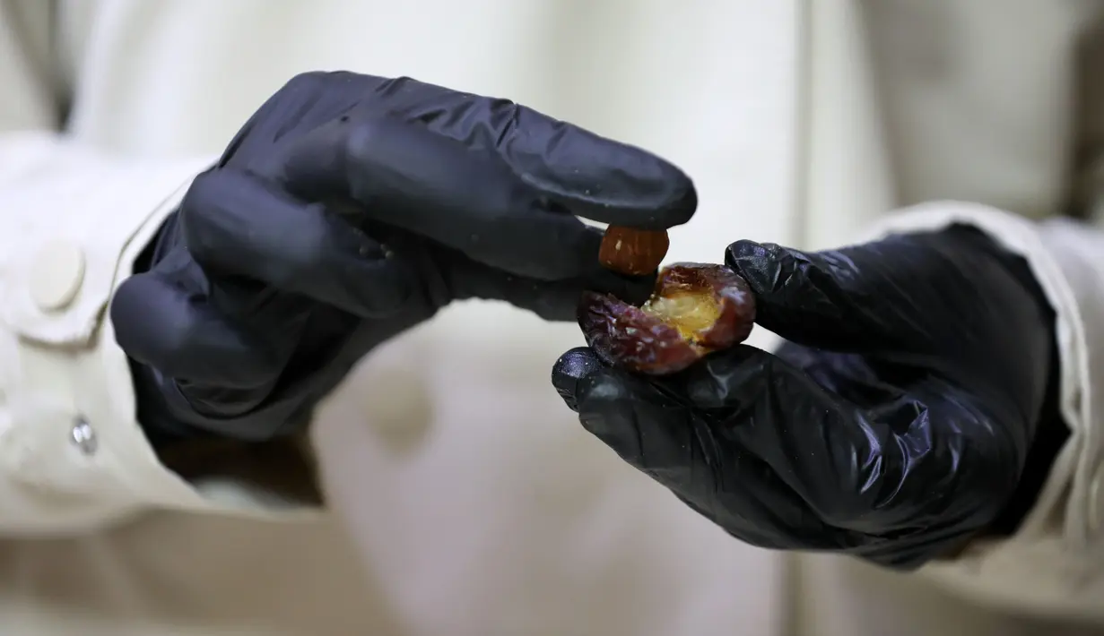 Wanita Palestina bernama Sojood Silwadi membuat kurma berlapis cokelat di rumahnya di Kota Nablus, Tepi Barat, 15 November 2020. Silwadi (26) merintis proyeknya setahun lalu. (Xinhua/Ayman Nobani)