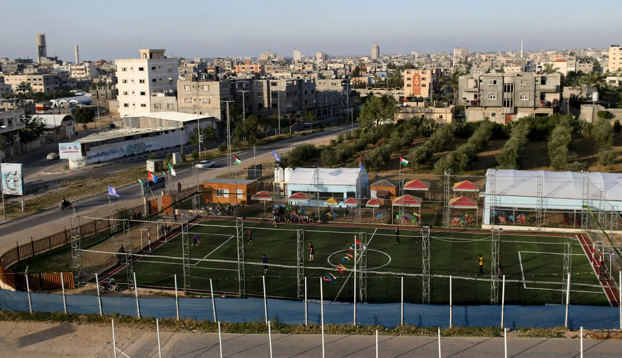 Warga Palestina bermain sepak bola di lapangan futsal, Khan Younis, Jalur Gaza, (4/6). Meski negara tersebut mengalami berbagai konflik tetapi mereka tetap menghibur diri dengan bermain bola bersama. (REUTERS / Ibraheem Abu Mustafa)
