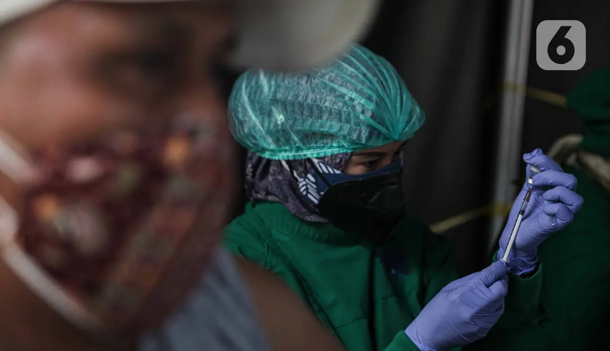 Tenaga kesehatan bersiap menyuntikkan vaksin COVID-19 dosis ketiga kepada warga di Puskesmas Kecamatan Kramat Jati, Jakarta, Rabu (12/1/2022). Pemerintah memulai program vaksinasi lanjutan (booster) COVID-19 secara gratis kepada masyarakat umum. (Liputan6.com/Faizal Fanani)